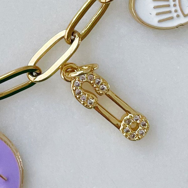 Klein gouden bedeltje van een safetypin met zirconia steentjes. Ideaal voor aan een bedelketting of armband.