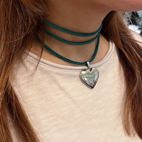 Groene  koord ketting met een groot zilveren medaillon hart. Het koord is er in zwart, groen, roze, grijs en bruin.