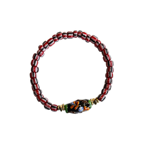 Beadies armband met rood, wit en zwart gestreepte kralen met een ovale bohemian bloemkraal in het midden.