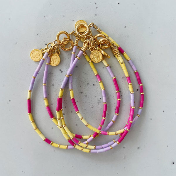 Geregen armbandje met kleine tube kralen in geel, roze en lila. Ideaal voor je zomer outfit.