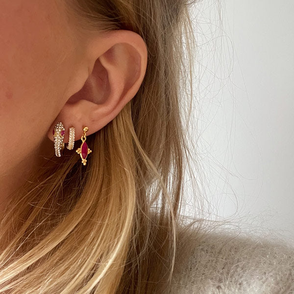 set van 3 gouden oorbellen waaronder een klein kristallen oorring, een slang en een roze halfedelsteen bedeltje.