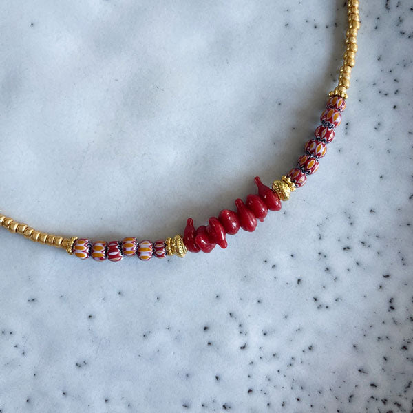 Korte ketting met burgundy rode chevron kraaltjes en gouden rocailles. Mix dit kettinkje met een half lange gouden schakel of andere korte geregen kettinkjes.
