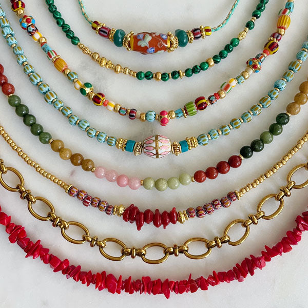 gekleurde festival kettingen met warme kleuren glaskralen burgundy rood, malachiet groen en koraal rood. 