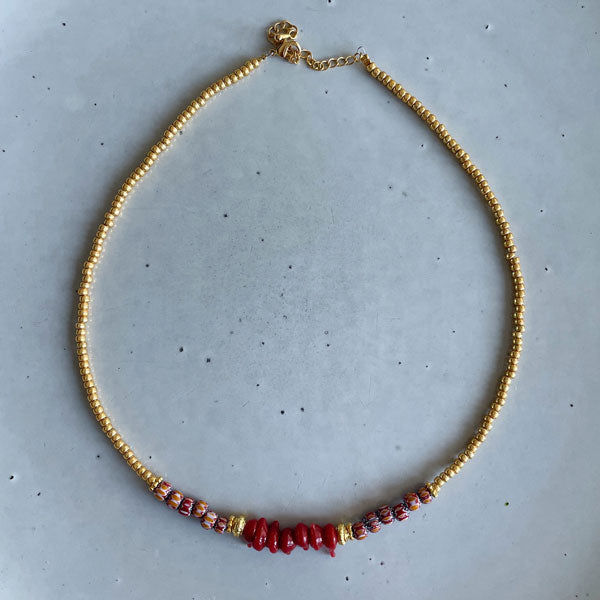 Korte ketting met burgundy rode chevron kraaltjes en gouden rocailles. Mix dit kettinkje met een half lange gouden schakel of andere korte geregen kettinkjes.