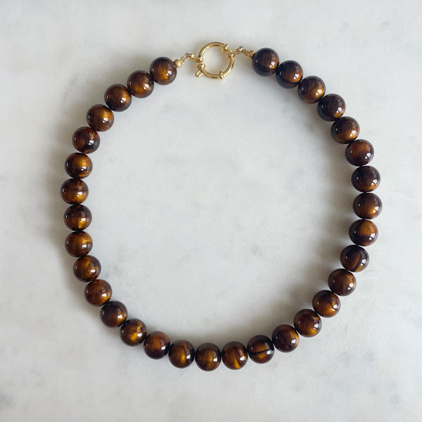 ketting met grote ronde bruine kralen met een gouden boeisluiting van stainless steel