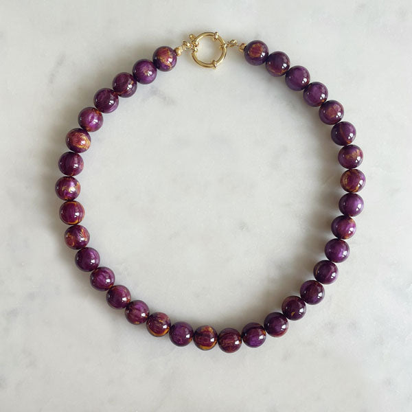 Deze ketting is geregen met grote ronde paars bruine kralen. Een ideale ketting als je van warme kleuren houdt.