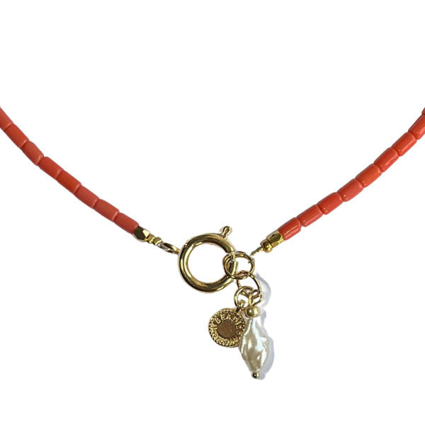 koraalroze ketting met gouden boeislot met als hanger een gouden munjte en een zoetwaterparel