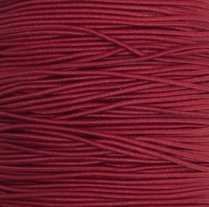een rol met bordeauxrood gekleurd elastiek om sieraden van te maken