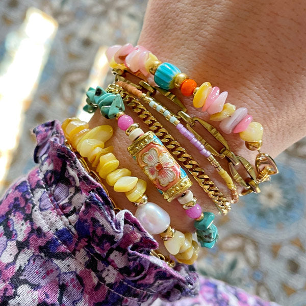 pols met vrolijke kleurrijke kralen armbanden met edelstenen in roze, geel en turkoois